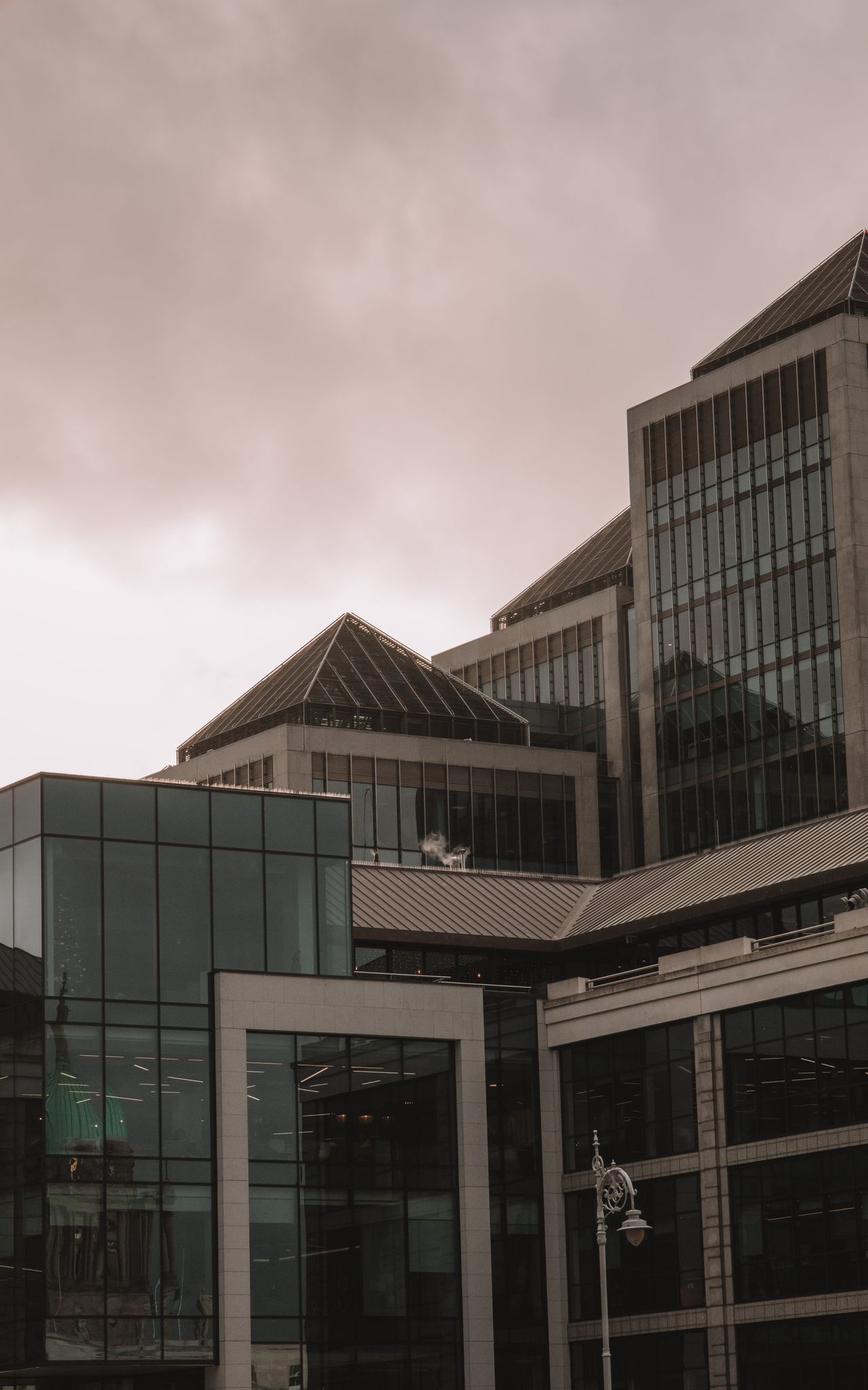 A dramatic view of modern office buildings in Dublin, Ireland under a moody gray sky.