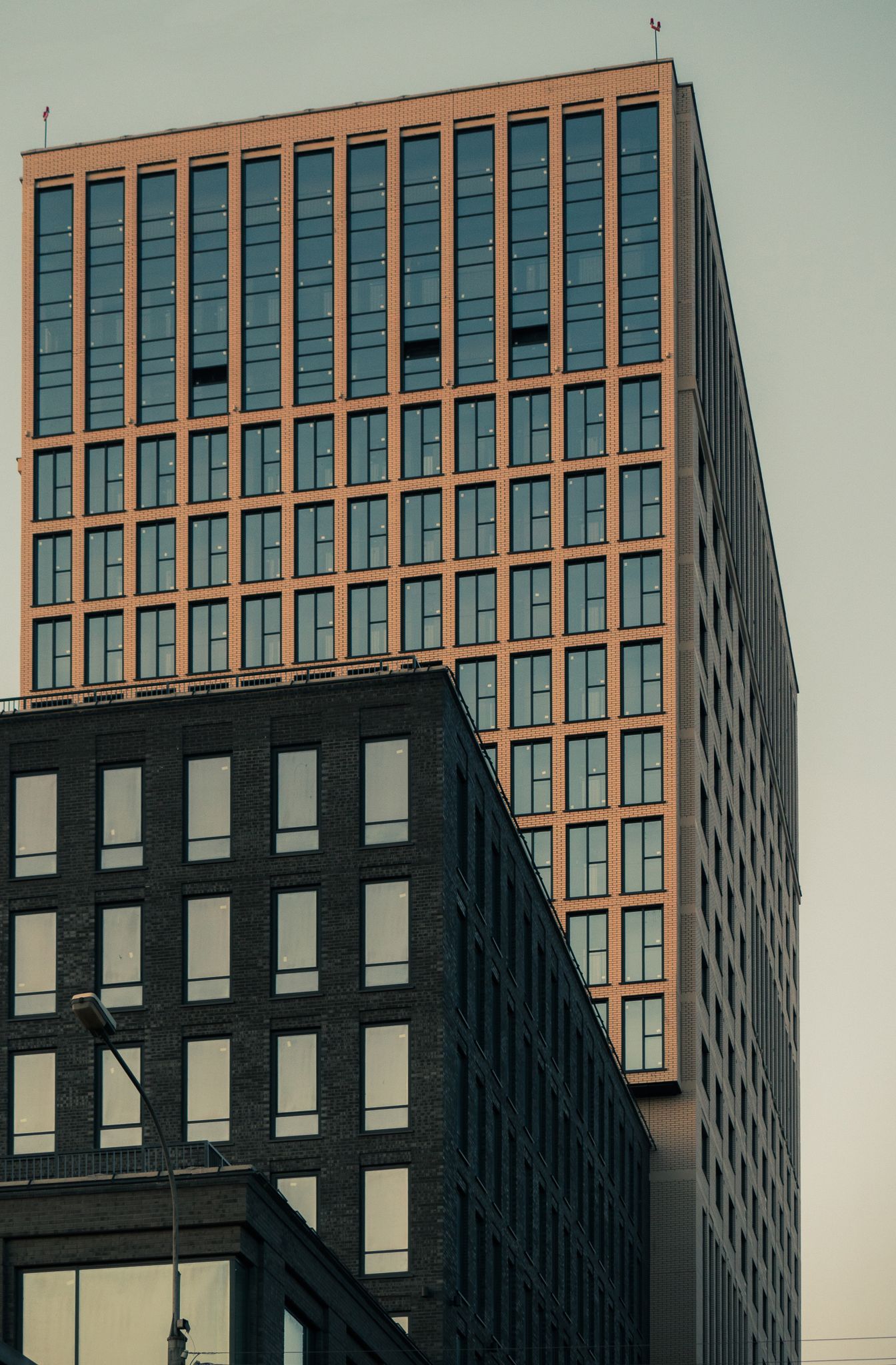 A modern high-rise office building in Novosibirsk at dusk with a sleek facade.